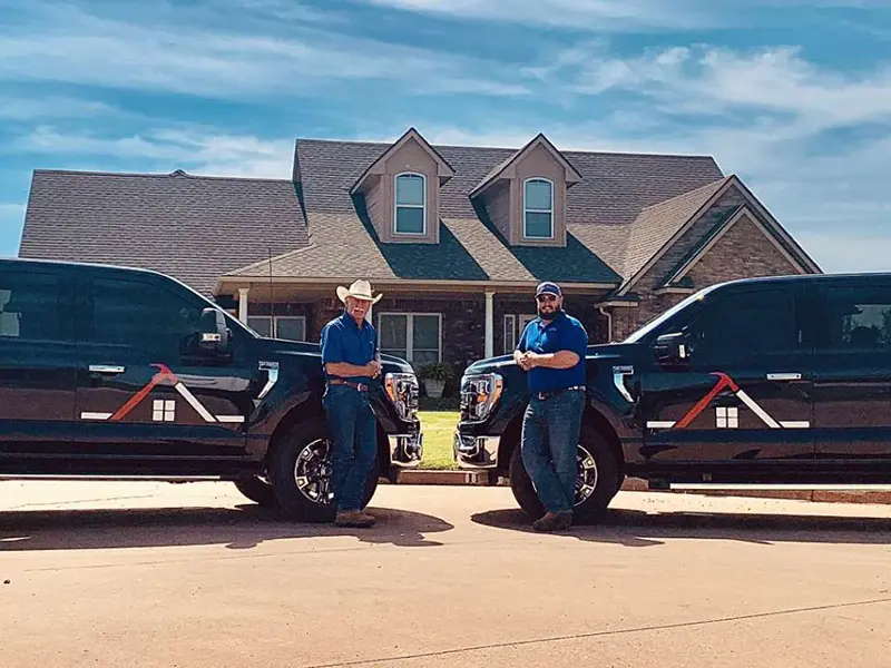 Crew members in front of home and work trucks