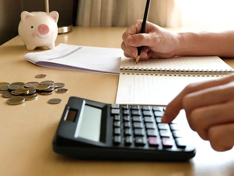 Person using calculator and writing notes