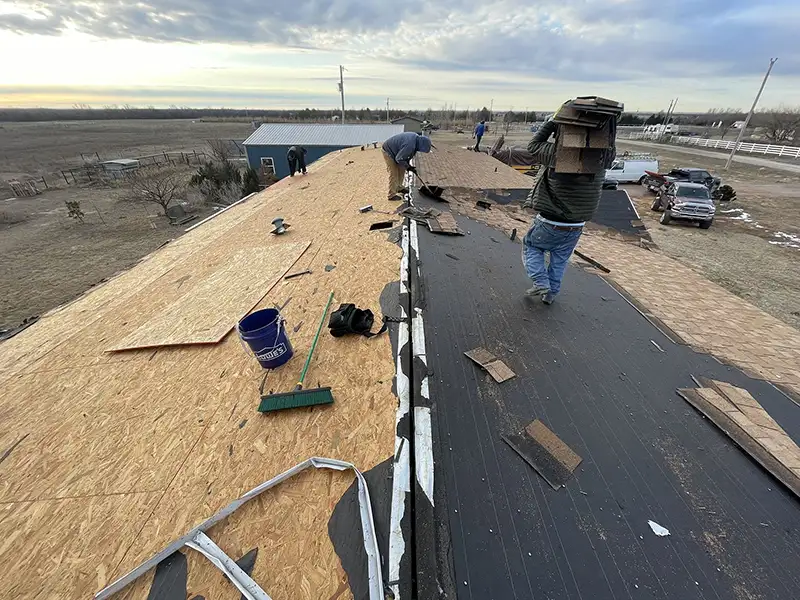 Crew removing shingles from roof